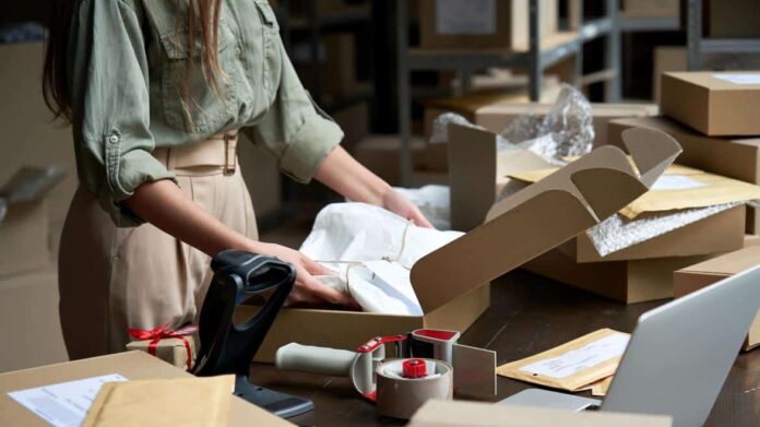 Una mujer guarda una ropa en una caja