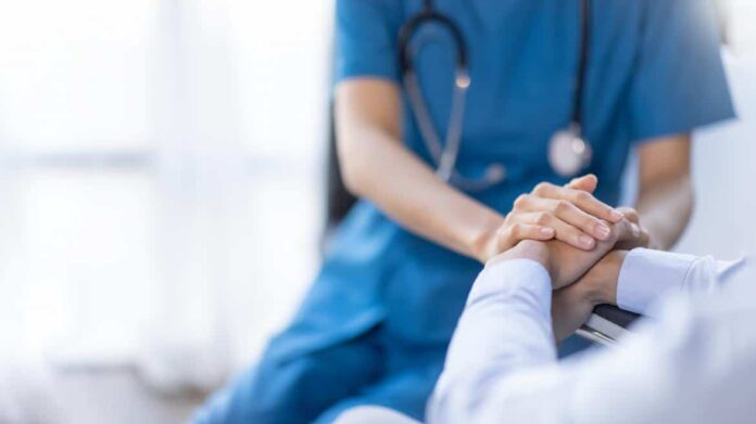 Una doctora le da la mano a un paciente