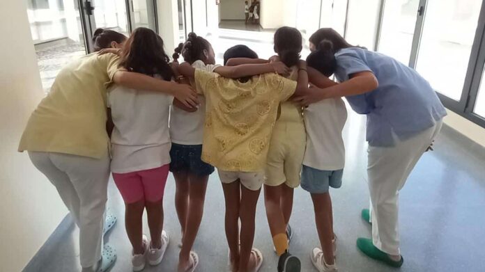 Niños de espaldas con profesionales sanitarias