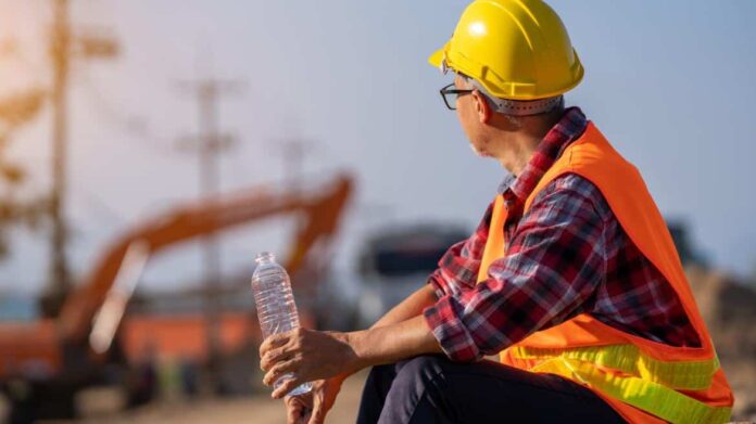 Trabajador de la construcción bebiendo agua por el calor