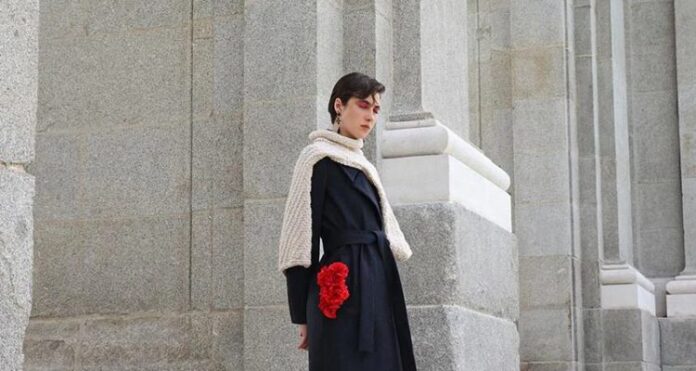 Modelo con gabardina negra posa frente a la Puerta de Alcalá