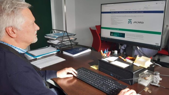 Héctor Bueno trabajando frente al ordenador en una pantalla qonde aparece el nombre del proyecto europeo JACARDI