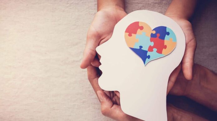 manos sujetando una cabeza con un corazón de colores dentro
