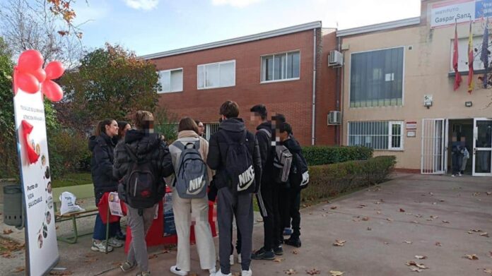 jovenes en la entrada de su instituto en una mesa informativa del centro de salud