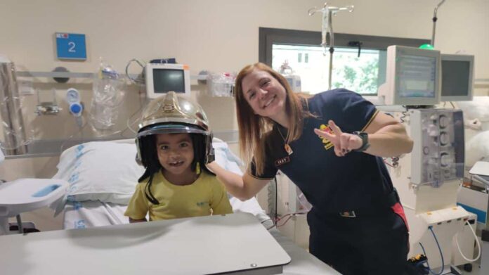 Un niño con el casco de una de las bomberos de la Comunidad de Madrid