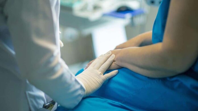 Imagen de un profesional sanitario junto a un paciente