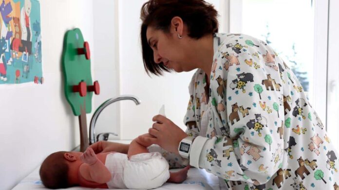 Trabajadores del Hospital Público El Escoriala atendiendo a un bebé