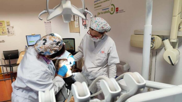 Profesionales de una Unidad de Salud Bucodental de Atención Primaria atienden a un paciente en el gabinete dental