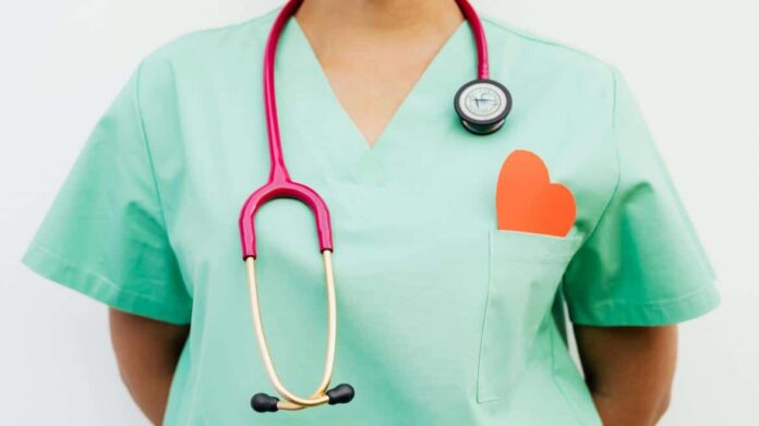 Médico con fonendoscopio y corazón en el bolsillo del uniforme sanitario