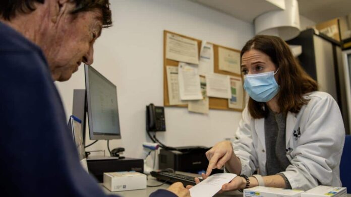 paciente y farmacéutico explicando información sobre medicamentos