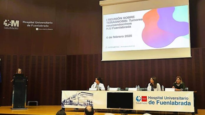 Personas sentadas en una mesa dentro de un auditorio