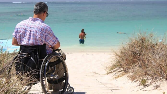 imagen de hombre en silla de ruedas en la playa