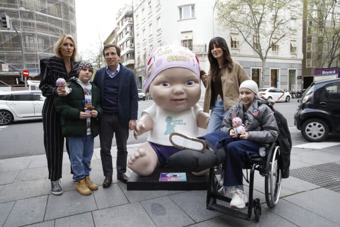 1.Almeida posa al lado de la figura diseñada por Elena Huelva, de la exposición de baby pelones de Juegaterapia