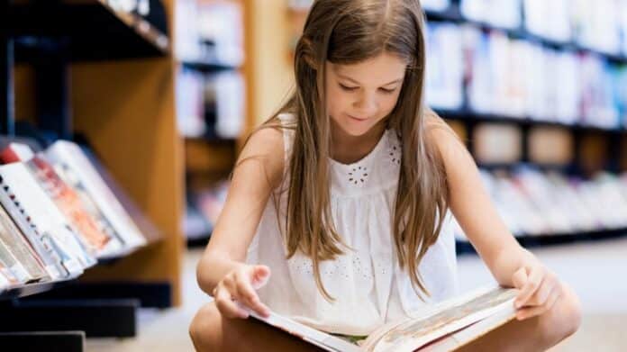 niña leyendo en una biblioteca