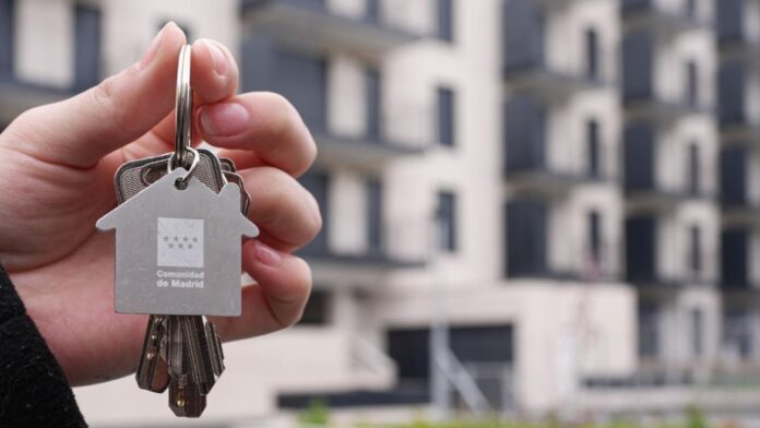 Mano con llaves con el logo de la Comunidad de Madrid AVS Agencia de Vivienda Social