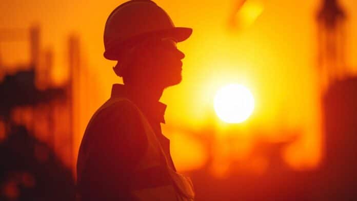 perfil trabajador obra con sol de fondo