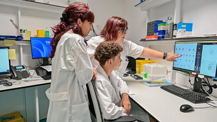 Dos alumnos aprenden ciencia en un laboratorio junto a un sanitario