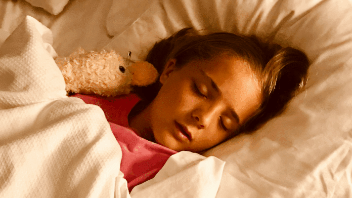 Imagen de una niña durmiendo en la cama