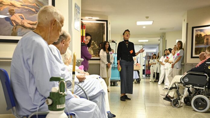 Los pacientes escuchan a una cantante en un pasillo de un hospital