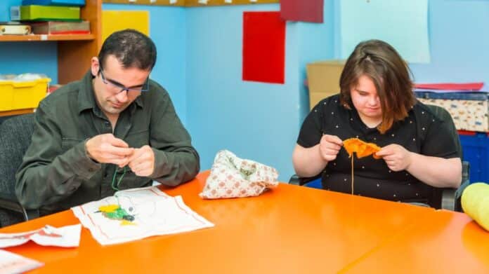 Personas con discapacidad intelectual tejiendo ropa con lana en una guardería