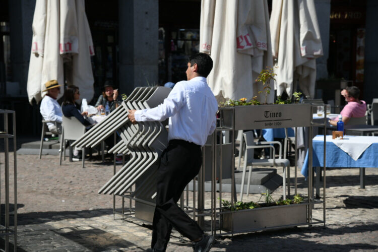 Un-trabajador-de-la-hosteleria-coloca-unas-sillas-en-la-plaza-Mayor